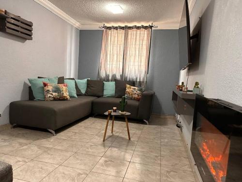 a living room with a couch and a tv at Departamento hogareño Teziutlán in Teziutlán