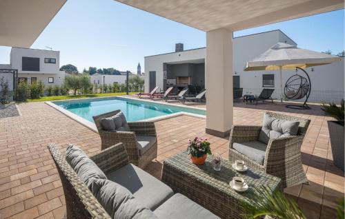 un patio avec des chaises et une piscine dans une maison dans l'établissement 4 Bedroom Nice Home In Kastelir, à Kaštelir