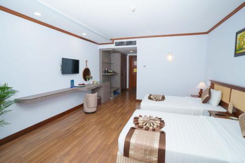a hotel room with two beds and a tv at Saigon - Ninh Chu Hotel & Resort in Phan Rang