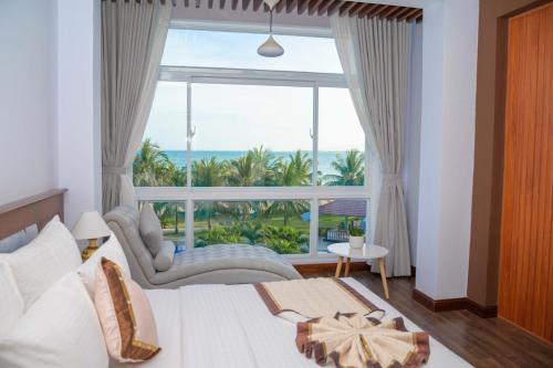 a bedroom with a bed and a large window at Saigon - Ninh Chu Hotel & Resort in Phan Rang