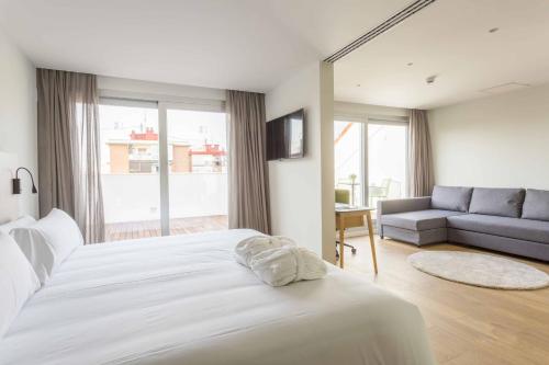 a bedroom with a white bed and a couch at ARTIEM Madrid in Madrid