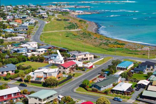 an aerial view of a small town next to the ocean at A Classic Kiwi Bach in South Bay in Kaikoura