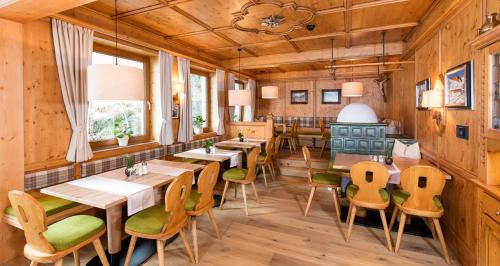 オーバーグルグルにあるHaus Hohenfelsの木製の壁とテーブルと椅子が備わるレストラン