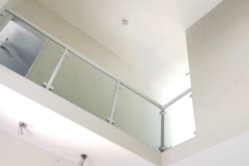 een trap met een glazen leuning in een gebouw bij Martin de Sá-200 metros da praia in Caraguatatuba