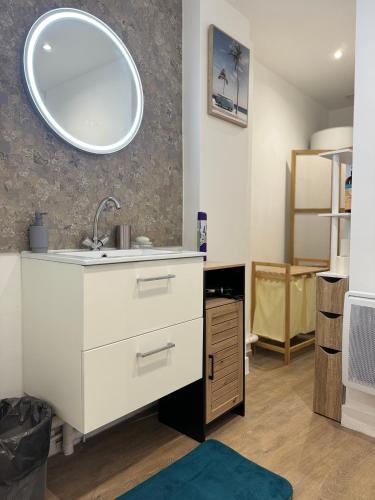 une salle de bain avec un lavabo et un miroir au mur dans l'établissement Escale 1, au Mans