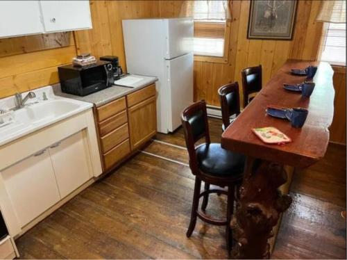 a kitchen with a table and a white refrigerator at Chinook Winds Lodge in Dubois