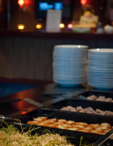 two trays of plates and food on a grill at Hotell Hulingen in Hultsfred