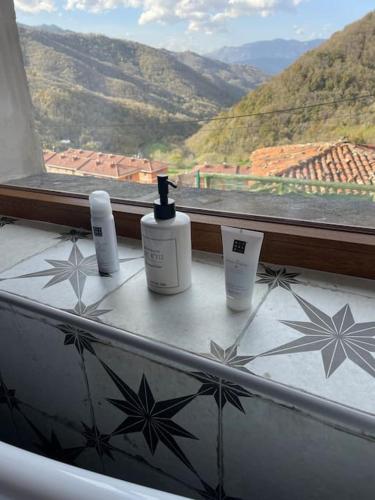 three bottles ofodorizers sitting on a window sill at El Balcón de Urbiés in Mieres