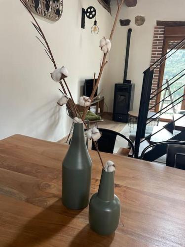 two vases sitting on a wooden table with flowers at El Balcón de Urbiés in Mieres