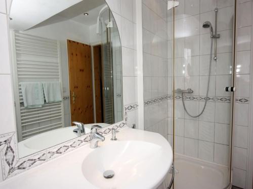 a bathroom with a sink and a tub and a mirror at Schwarzwaldgasthof Hotel Schwanen in Schonach