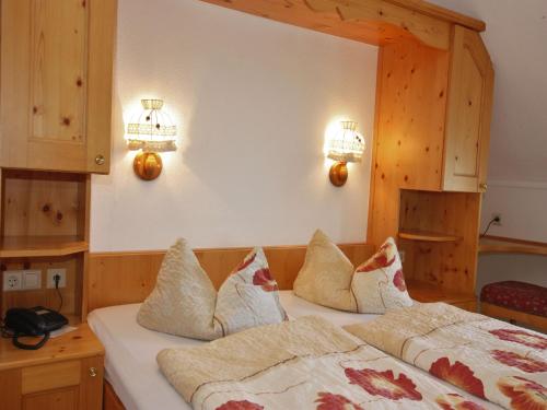 a bedroom with a bed and two lights on the wall at Schwarzwaldgasthof Hotel Schwanen in Schonach