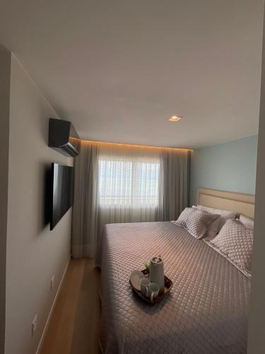 a bedroom with a bed with a tray with a candle at Paraíso Azul em Ponta Negra, Natal RN in Natal