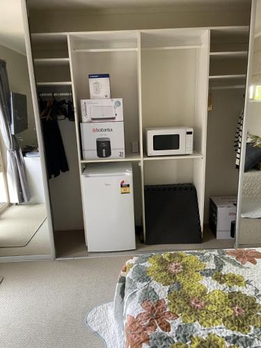 a room with a refrigerator and a microwave at Close motorway, free breakfast, Fabulous views, selfcontained in Auckland