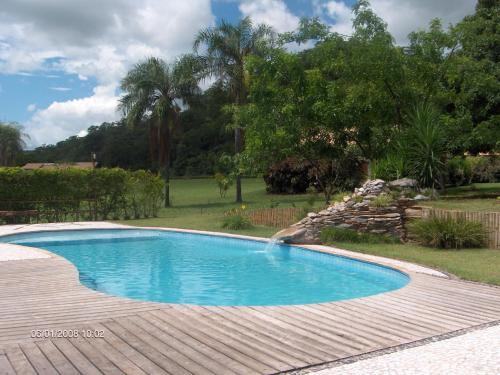 a swimming pool with a wooden deck around it at Pousada Moinho De Vento in Bonito