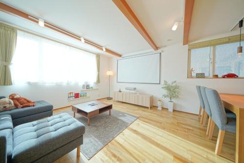 a living room with a couch and a table at Casa Antonio B 木の温もり 駅近&空港バス 駐車場付 in Sapporo