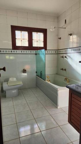 a bathroom with a tub and a toilet and a sink at Recanto Itapeva Garden in Itapeva