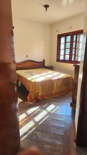 a bedroom with a bed in the corner of a room at Recanto Itapeva Garden in Itapeva