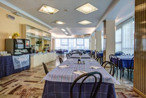 a row of tables in a restaurant with blue table cloth at Hotel San Paolo in Rimini