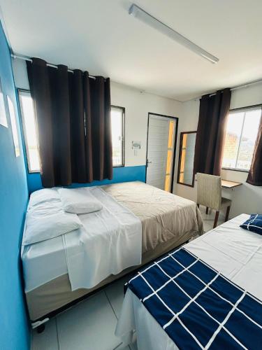a bedroom with two beds and a table and chairs at Flat Rainha da Serra in Bezerros