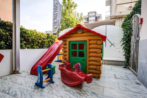 a playground with a slide and a play house at Hotel San Paolo in Rimini