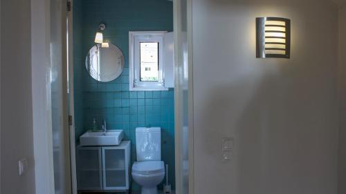 a bathroom with a toilet and a sink and a window at Porto Beach House in Porto