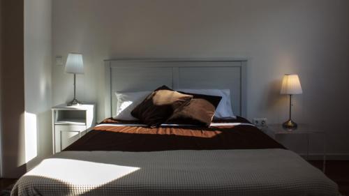 a bedroom with a large bed with two lamps at Porto Beach House in Porto