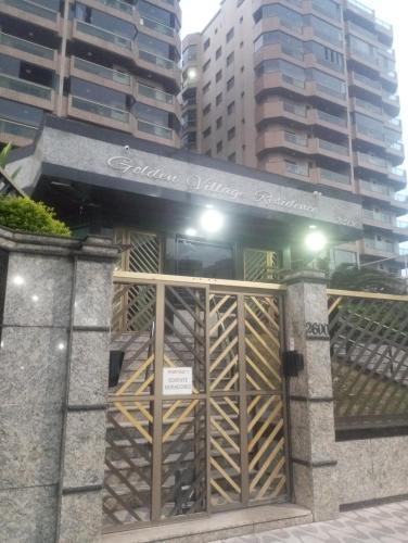 a gate at the entrance to a building at Apto com Piscina - Lazer Completo-Mongaguá centro in Mongaguá