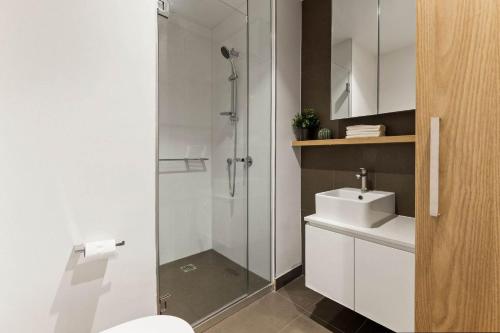 a bathroom with a shower and a toilet and a sink at Stylish 2BR Apartment with Panoramic City Views in Melbourne