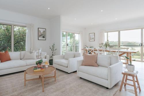 a living room with two white couches and a table at Morning Sun Vineyard in Main Ridge