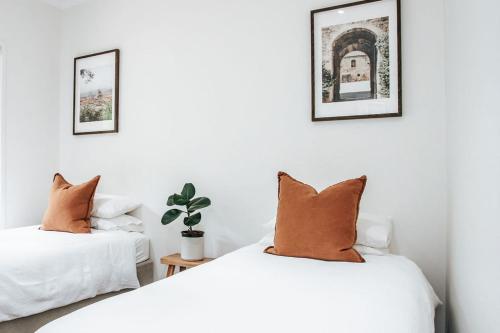 Main RidgeにあるMorning Sun Vineyardの白い壁の客室で、枕付きのベッド2台が備わります。