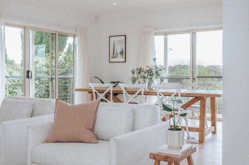 a living room with a white couch and a table at Morning Sun Vineyard in Main Ridge