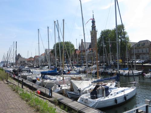 a group of boats docked in a harbor with a clock tower at Boerderijcamping Plantlust in Veere