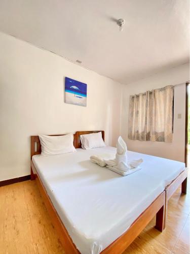 a large white bed with a hat on top of it at Elsa's beach house in Itaytay