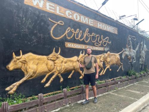 a man standing in front of a wall with animals at Maria Kulafu Studio Apartment Kinamaligan- Beside Eglin Gas FREE Wifi in Masbate