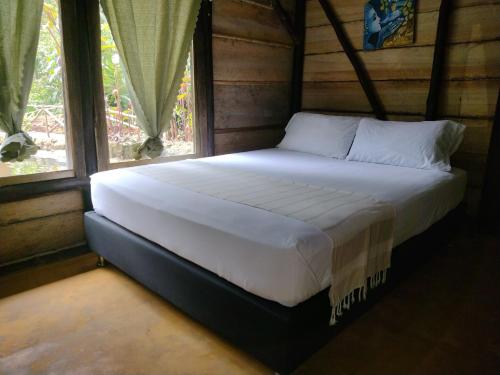 a large bed in a room with a window at Sapiens house cabaña del lago clásica in Cali