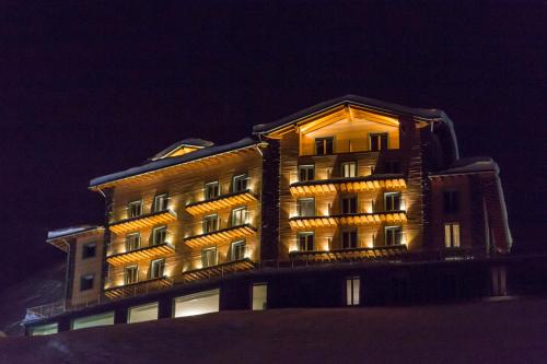 a building with lights on it at night at White Angel Hotel in Breuil-Cervinia
