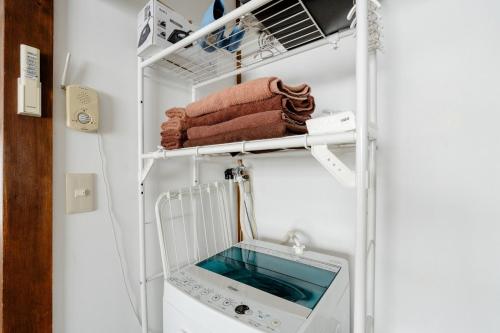 a room with a washing machine and towels at Chelsea Hatsudai 201 CH21 in Tokyo