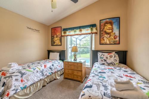 a bedroom with two twin beds and a window at Safari Lodge in Orlando