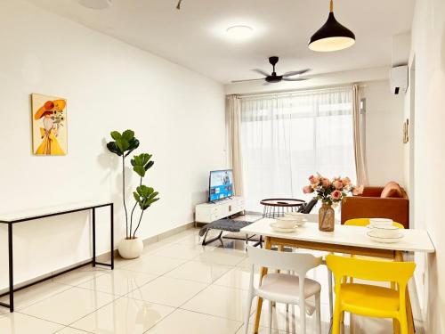 a living room with a dining room table and yellow chairs at Kulai d putra suites beside ioiMall near JPO and Airport in Kulai