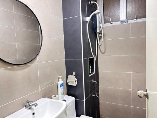 a bathroom with a toilet and a sink and a mirror at Kulai d putra suites beside ioiMall near JPO and Airport in Kulai