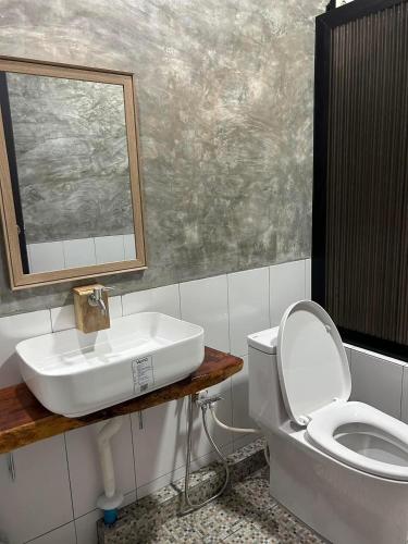 a bathroom with a sink and a toilet and a mirror at Him Doi Villa ฮิมดอยวิลล่า in Ban Na Kham