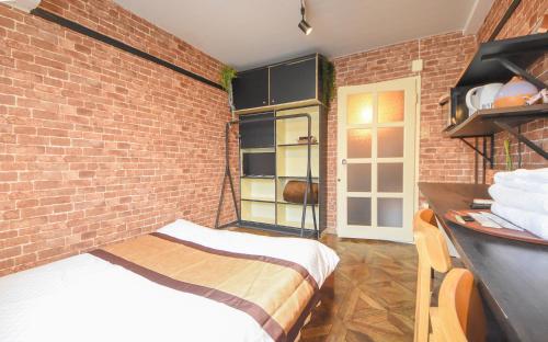 a bedroom with a brick wall and a bed at Comfy Stay Sakuramachi in Nara
