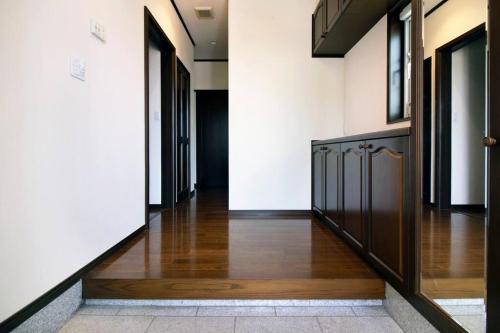 a hallway with wood flooring and doors in a building at Roopt陸前赤井 in Higashimatsushima