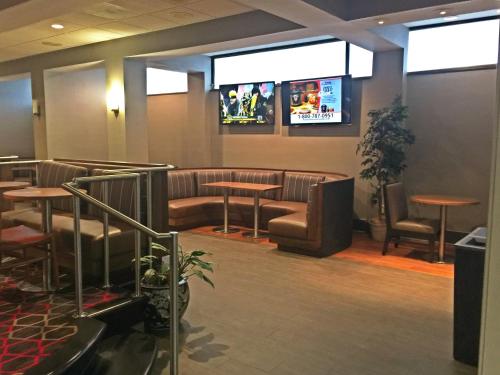 a restaurant with tables and chairs and a tv at Wyndham Garden Inn Pittsburgh Airport in Robinson Township