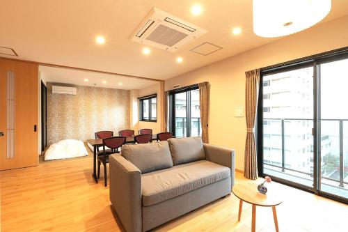 a living room with a couch and a table at TEN APARTMENT HOTEL Hakata Reisen in Fukuoka
