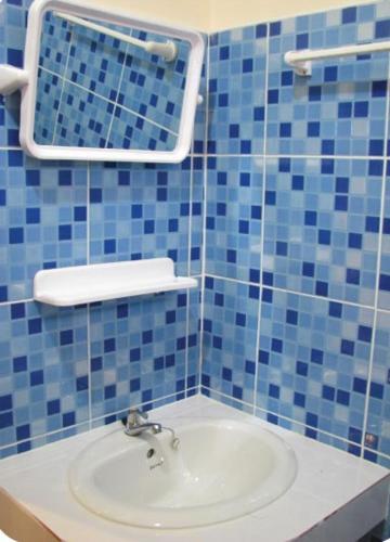 a bathroom with a sink and a blue tiled wall at Krabi Discovery Resort in Tha Lane Bay