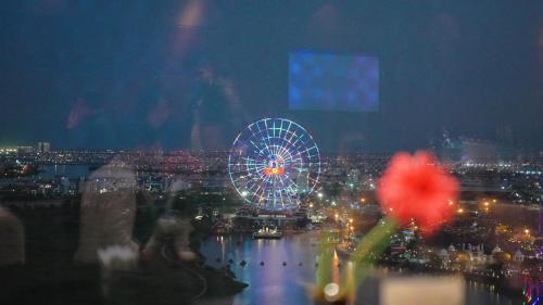 a view of a ferris wheel and a city at night at Grand Mercure Danang in Da Nang