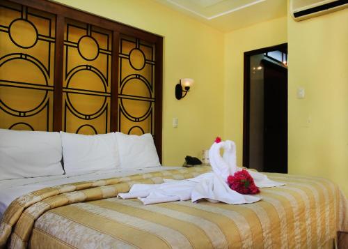 a hotel room with a bed with a swan on it at Hotel Residencial in Mérida