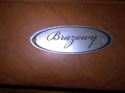 a metal sign on a brown surface with the word biography at Apartamenty Lawenda in Rabka