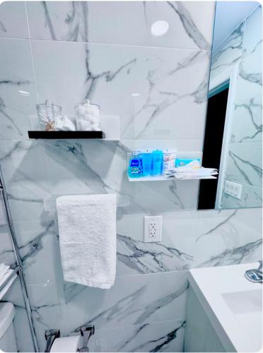 a bathroom with white marble walls and a mirror at Exquisite 3 Bedrooms in Newark